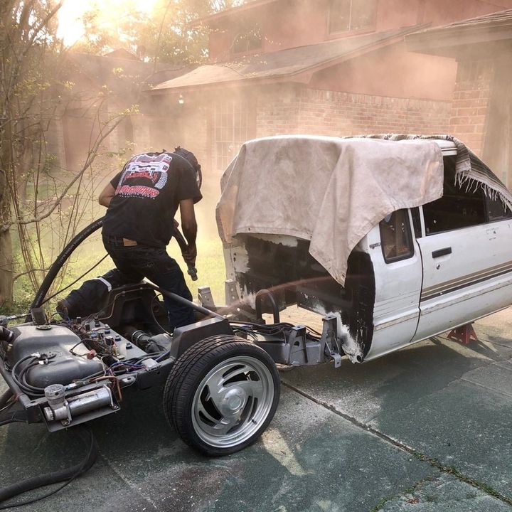 A man working on a car with a cover on it